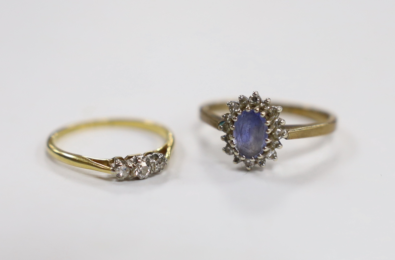 An 18ct, plat and three stone diamond chip set ring, size M and a modern 9ct gold, sapphire and diamond set oval cluster ring.